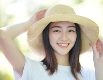 女性が帽子をかぶってこちらを向ている様子